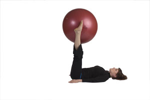 Contracción abdominal con bola grande extendiendo las pierna